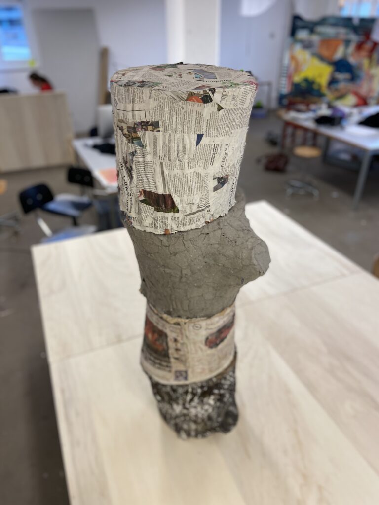 Baumstammskulptur aus verschiedenen Papierkompositionen.